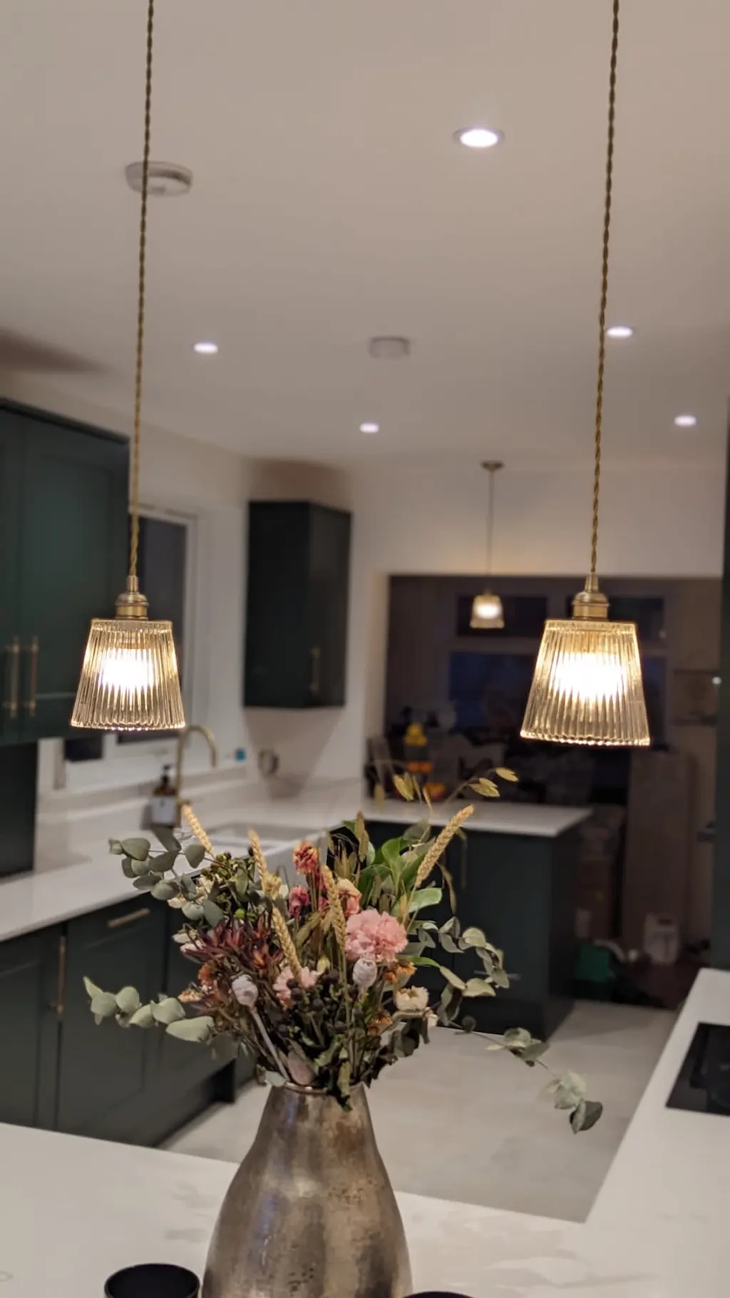 Glass pendant lights and recessed ceiling lighting in a modern kitchen
